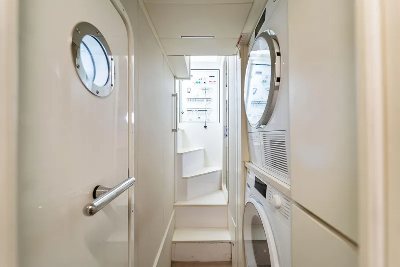 Giulia Yacht Photos Pics Laundry area inside 2023 Ferretti Yachts 670, featuring stacked washer and dryer.