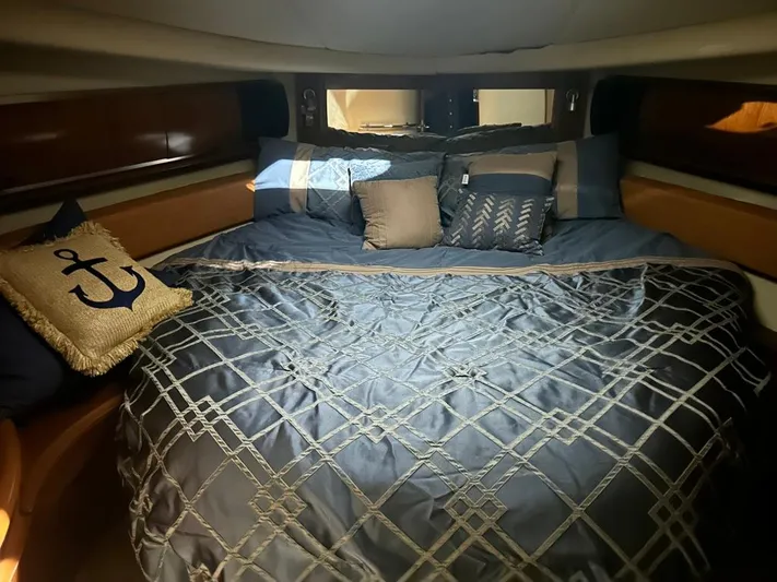 Yacht Photos Pics Luxurious cabin interior of 2005 Sea Ray Sundancer 520 with elegant bedding and nautical-themed decor.