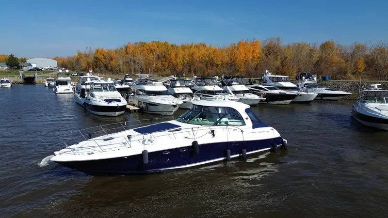  Yacht Photos Pics 2005 Sea Ray Sundancer 520 yacht docked in a marina with autumn trees in the background.