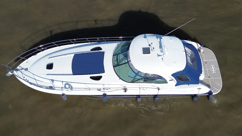  Yacht Photos Pics 2005 Sea Ray Sundancer 520 yacht, aerial view, white hull, blue accents, docked in calm water.