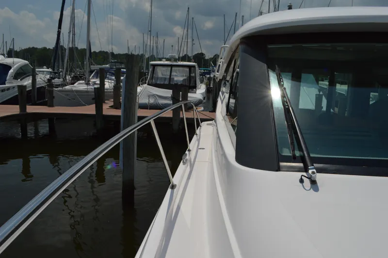  Yacht Photos Pics 2019 Tiara Yachts C39 Coupe docked at marina, side view with railing and windshield.