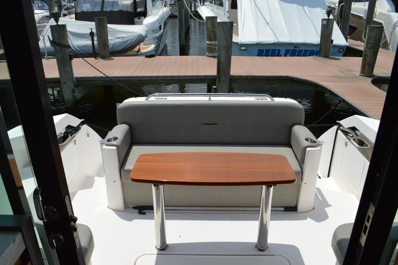  Yacht Photos Pics 2019 Tiara Yachts C39 Coupe cockpit with seating and wooden table, docked at marina.