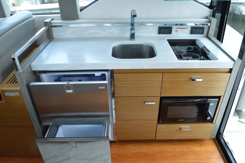  Yacht Photos Pics Modern yacht kitchen with sink, stove, microwave, and fridge in 2019 Tiara Yachts C39 Coupe.