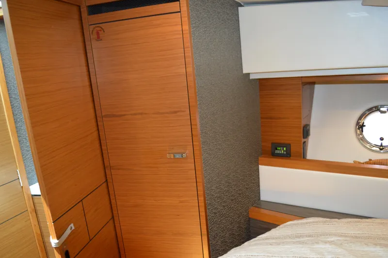  Yacht Photos Pics Interior cabin of 2019 Tiara Yachts C39 Coupe with wooden cabinetry and porthole.