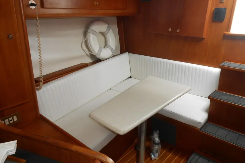 Beer Money Yacht Photos Pics 2004 Topaz 32 Express cabin with white seating, table, and wooden interior.