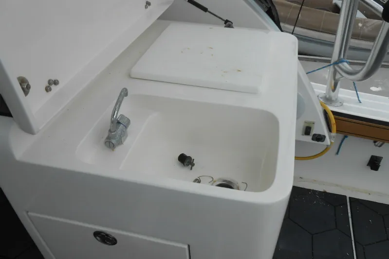 Beer Money Yacht Photos Pics 2004 Topaz 32 Express boat sink with faucet and storage compartment.