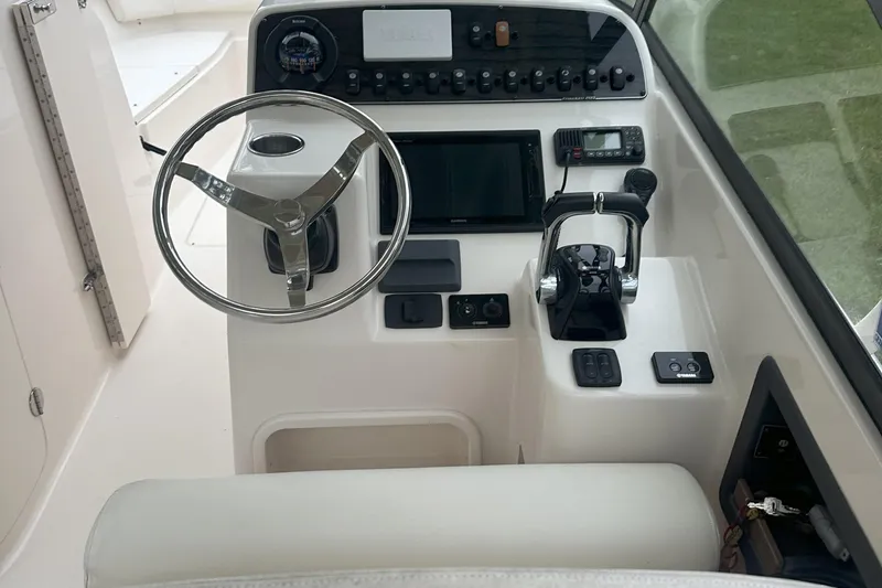Seas The Day Yacht Photos Pics 2015 Grady-White Freedom 285 boat dashboard with steering wheel and control panel.