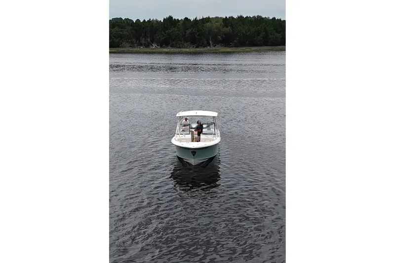 Seas The Day Yacht Photos Pics 2015 Grady-White Freedom 285 boat on calm water with forested shoreline.