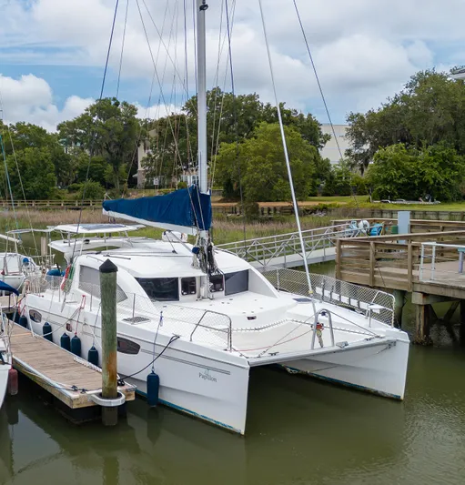 Papillon Yacht Photos Pics 2012 Leopard 39 catamaran docked at a marina with lush greenery.