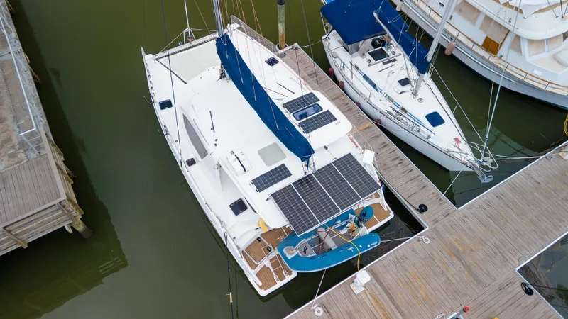 Papillon Yacht Photos Pics Aerial view of a 2012 Leopard 39 catamaran docked, featuring solar panels and blue sail covers.