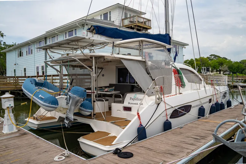 Papillon Yacht Photos Pics A 2012 Leopard 39 catamaran docked at a marina with a blue dinghy.