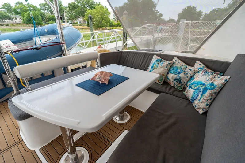 Papillon Yacht Photos Pics Cozy seating area on a 2012 Leopard 39 yacht with decorative pillows and a conch shell centerpiece.
