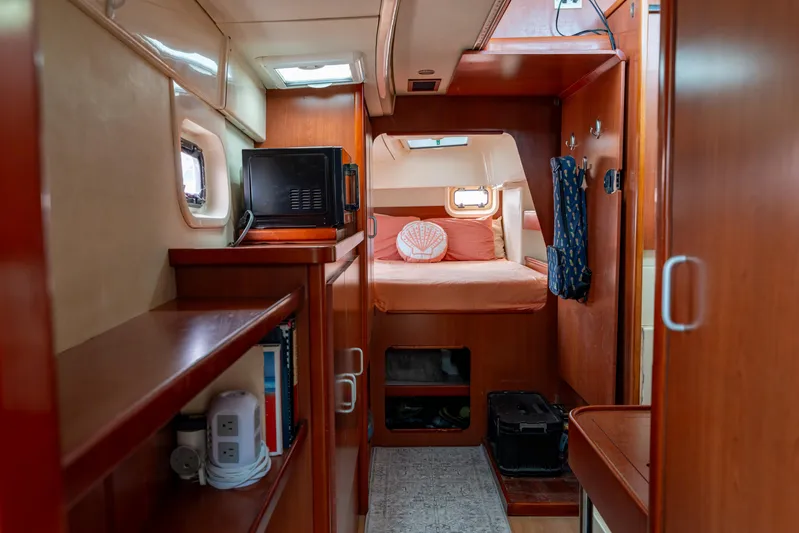Papillon Yacht Photos Pics Interior of 2012 Leopard 39 yacht cabin with bed, microwave, and wooden furnishings.
