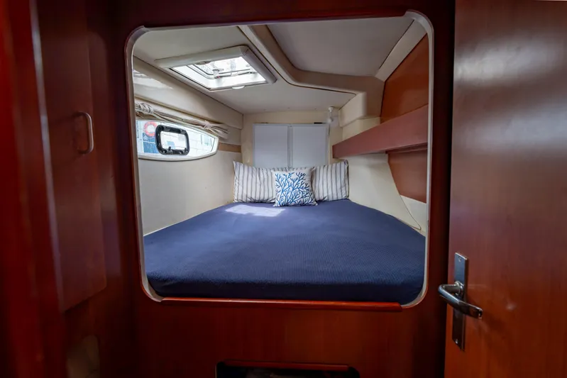 Papillon Yacht Photos Pics Cozy cabin interior of 2012 Leopard 39 yacht with bed and porthole.
