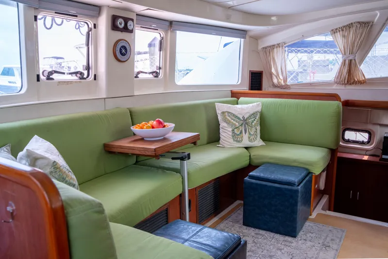 Papillon Yacht Photos Pics Interior of 2012 Leopard 39 yacht with green seating and a fruit bowl on the table.
