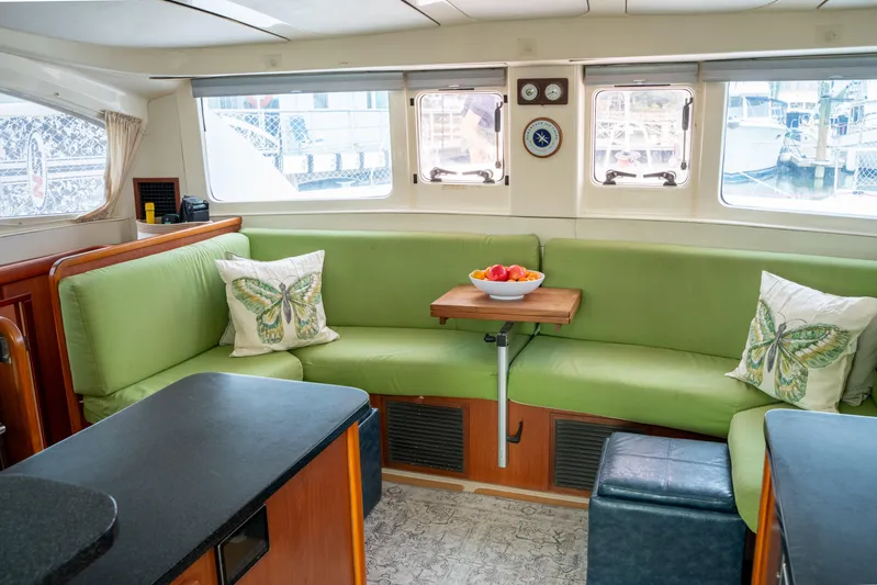Papillon Yacht Photos Pics Luxurious 2012 Leopard 39 yacht interior with green seating, butterfly pillows, and a wooden table.