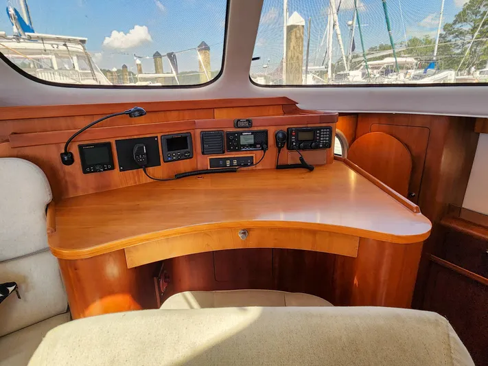 Frolic Yacht Photos Pics Navigation station inside 2014 Antares 44i yacht with control panels and wooden desk.
