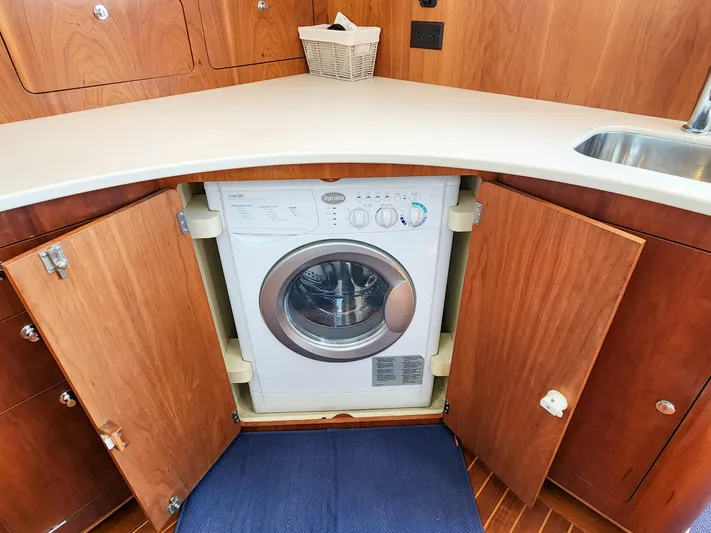 Frolic Yacht Photos Pics Washing machine in Antares 44i yacht kitchen, 2014 model, with wooden cabinetry and countertop.