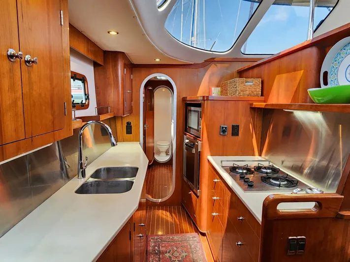 Frolic Yacht Photos Pics Luxurious Antares 44i yacht kitchen interior, 2014 model, featuring wood cabinetry and modern appliances.