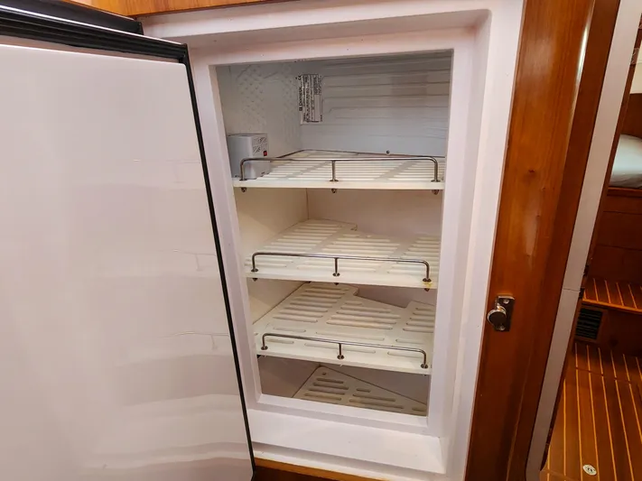 Frolic Yacht Photos Pics Open refrigerator with empty shelves inside a 2014 Antares 44i yacht.