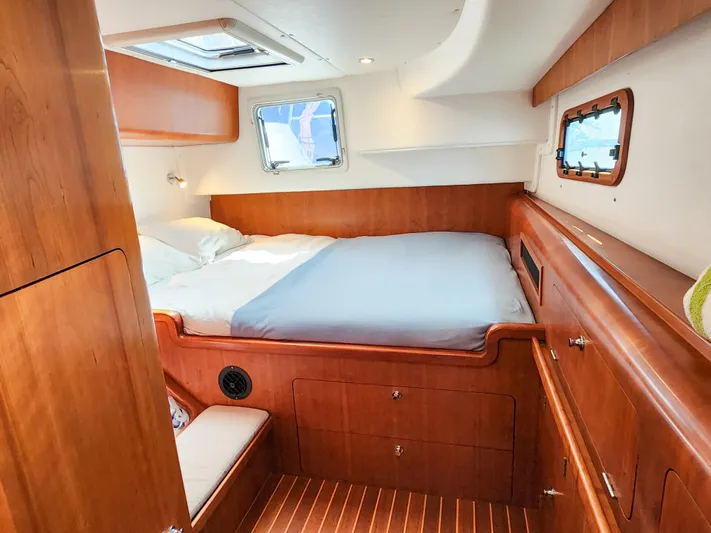 Frolic Yacht Photos Pics Cozy cabin interior of 2014 Antares 44i yacht with wooden furnishings and a comfortable bed.
