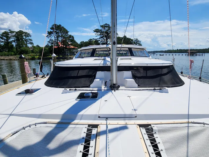 Frolic Yacht Photos Pics Catamaran Antares 44i, 2014 model, docked by a scenic waterfront with clear blue skies.