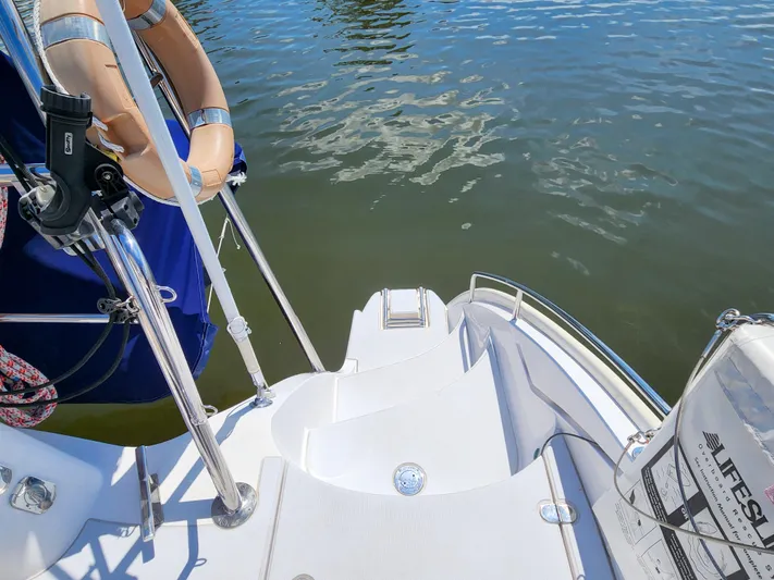 Frolic Yacht Photos Pics Stern view of 2014 Antares 44i sailboat with life preserver and water reflection.