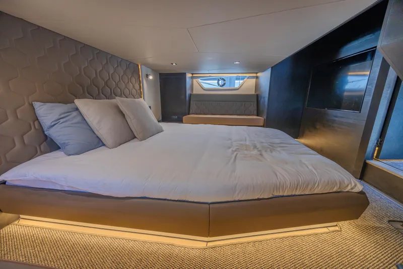 Moonshot Yacht Photos Pics Luxurious interior of 2023 Vanquish Yachts VQ58 with modern bedding and ambient lighting.