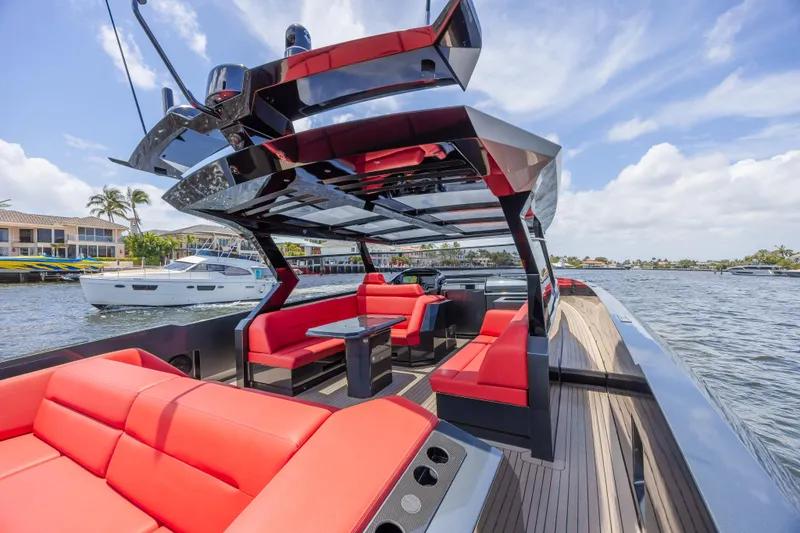 Moonshot Yacht Photos Pics Luxurious 2023 Vanquish Yachts VQ58 with sleek design and vibrant red seating on open water.