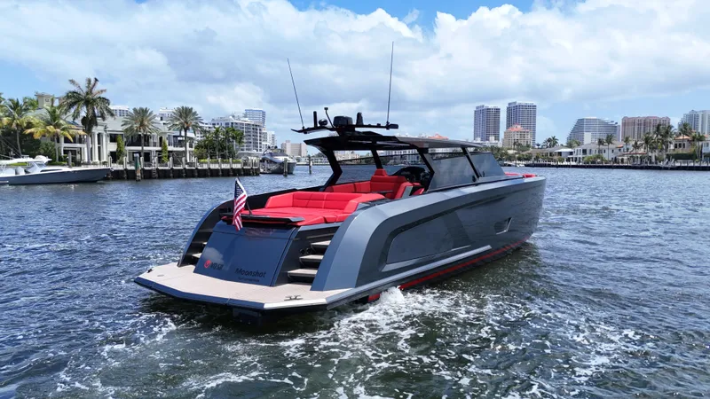 Moonshot Yacht Photos Pics 2023 Vanquish Yachts VQ58 cruising in a scenic waterfront cityscape.
