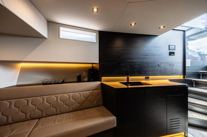 Moonshot Yacht Photos Pics Luxurious interior of 2023 Vanquish Yachts VQ58 with modern seating and sleek kitchen design.
