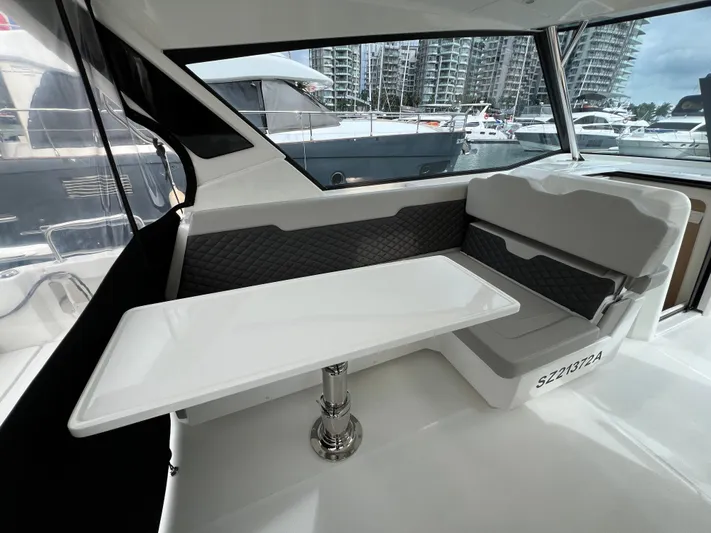  Yacht Photos Pics Interior of 2021 Aquila 36 Sport yacht with seating and table, docked at marina.