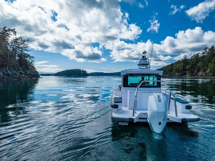 Windermere Yacht Photos Pics Axopar 28 boat cruising on a serene lake under a partly cloudy sky, 2022 model.