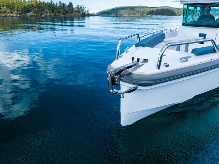 Windermere Yacht Photos Pics Axopar 28 boat, 2022 model, cruising on clear blue water near a forested shoreline.