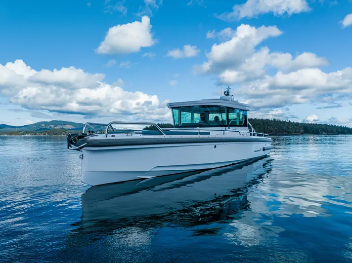 Windermere Yacht Photos Pics 2022 Axopar 28 boat cruising on a serene lake under a blue sky.