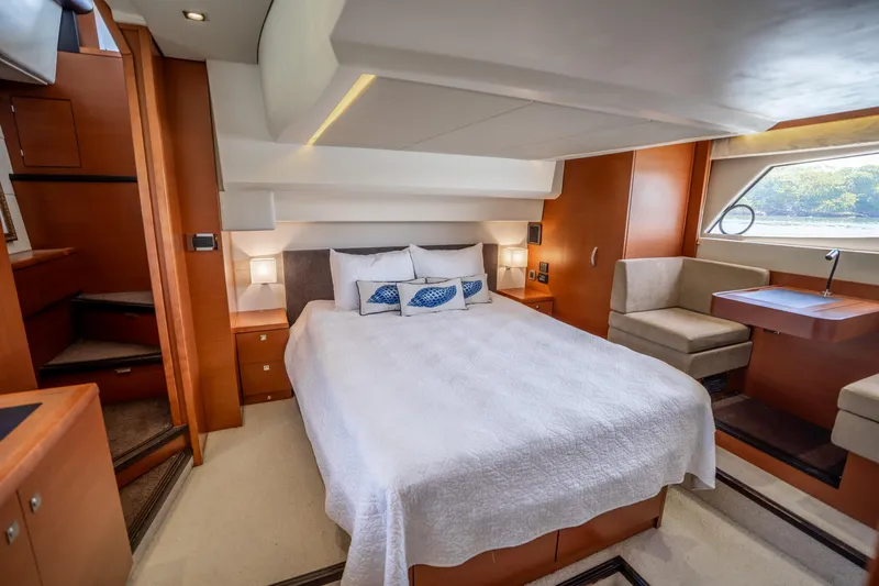  Yacht Photos Pics Luxurious cabin interior of a 2012 Prestige 500 Fly yacht with a cozy bed and seating area.