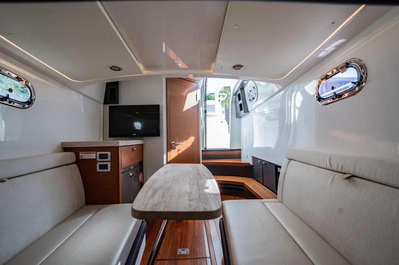  Yacht Photos Pics Interior of 2020 Pursuit S 408 Sport boat with seating, table, and TV.