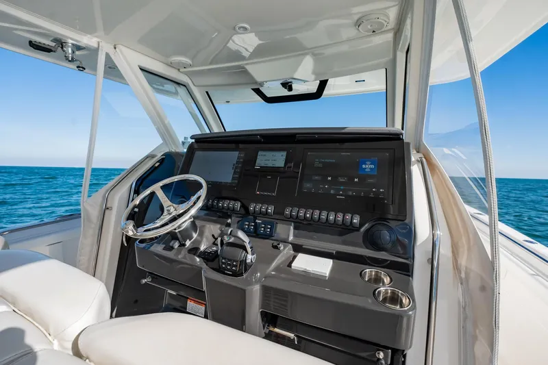  Yacht Photos Pics 2020 Pursuit S 408 Sport boat cockpit with modern controls and ocean view.