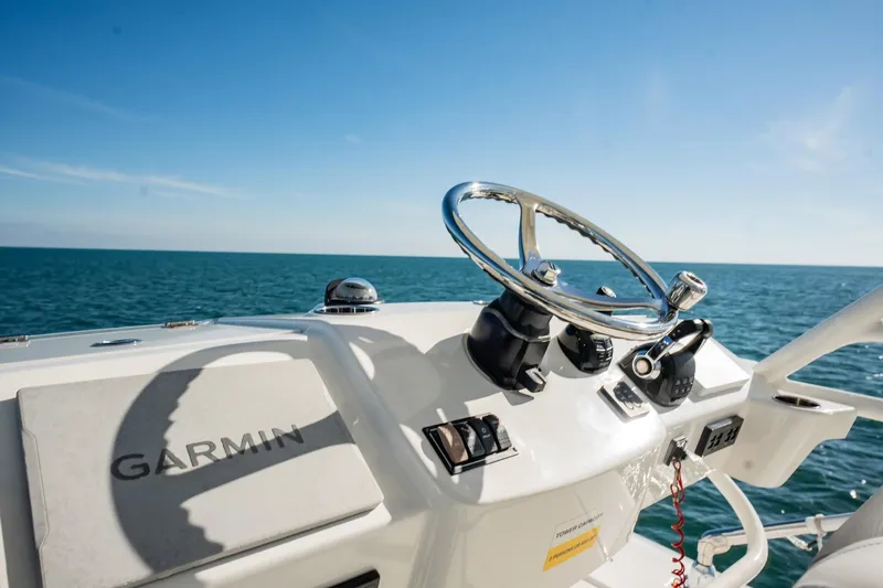  Yacht Photos Pics 2020 Pursuit S 408 Sport boat helm with Garmin navigation, steering wheel, and ocean view.