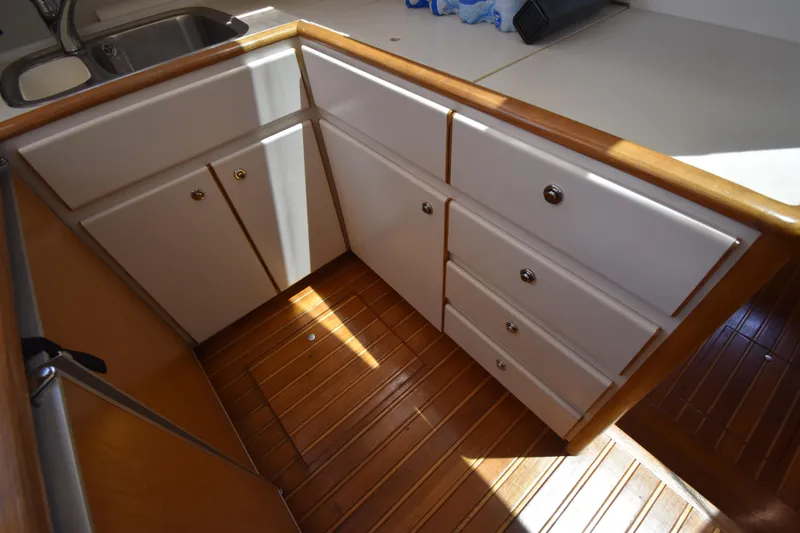 Yacht Photos Pics 1997 Tiara 4300 yacht interior with wooden flooring and white cabinetry.