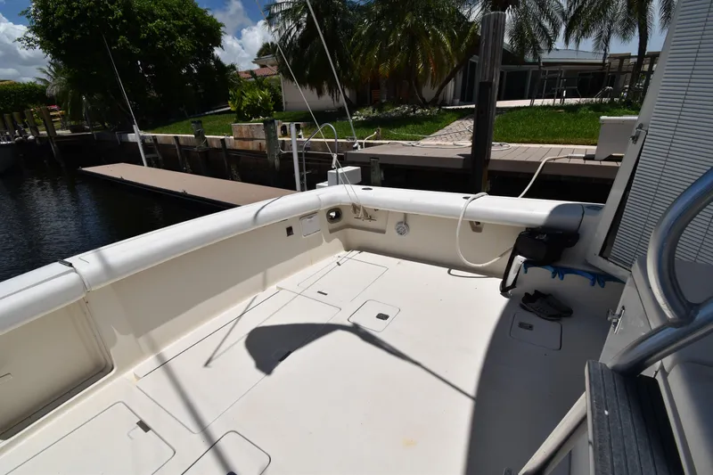  Yacht Photos Pics Spacious deck of a 1997 Tiara 4300 yacht docked by lush greenery.