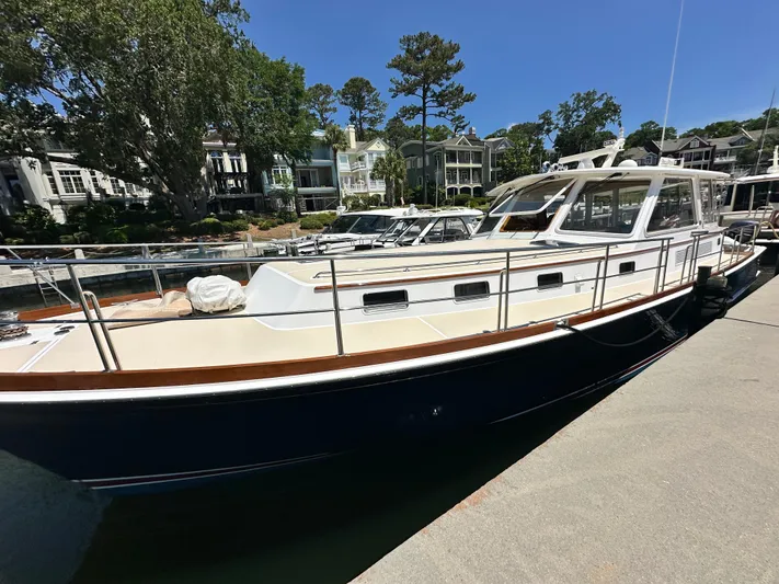 Bella Blue Yacht Photos Pics 2004 Grand Banks 49 Eastbay HX yacht docked in a marina, surrounded by trees and buildings.