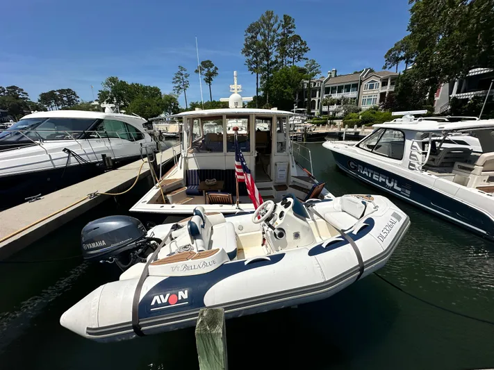 Bella Blue Yacht Photos Pics 2004 Grand Banks 49 Eastbay HX docked with inflatable boat, surrounded by other yachts.
