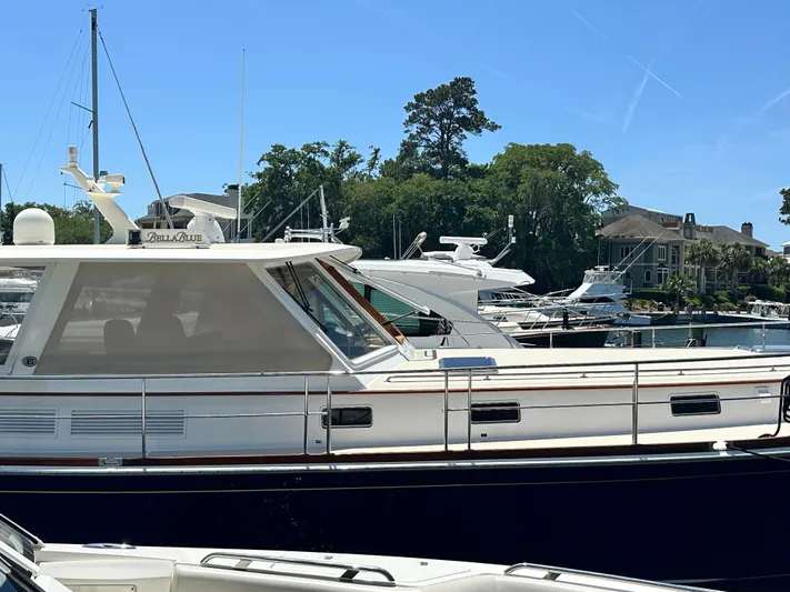 Bella Blue Yacht Photos Pics 2004 Grand Banks 49 Eastbay HX yacht docked at a marina on a sunny day.