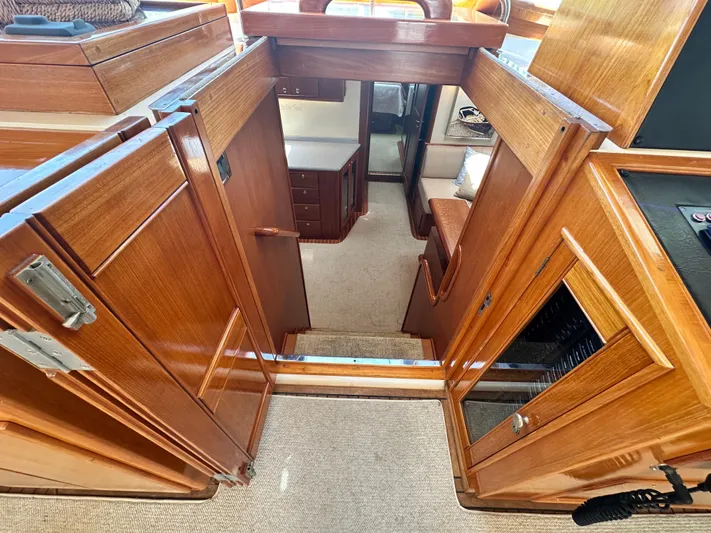 Bella Blue Yacht Photos Pics Interior view of 2004 Grand Banks 49 Eastbay HX yacht with wooden cabinetry and carpeted flooring.