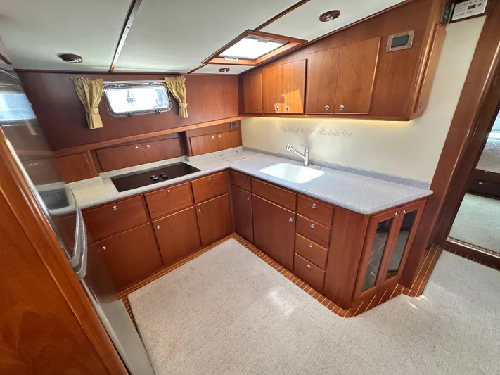 Bella Blue Yacht Photos Pics Luxurious 2004 Grand Banks 49 Eastbay HX yacht kitchen with wood cabinetry and modern appliances.