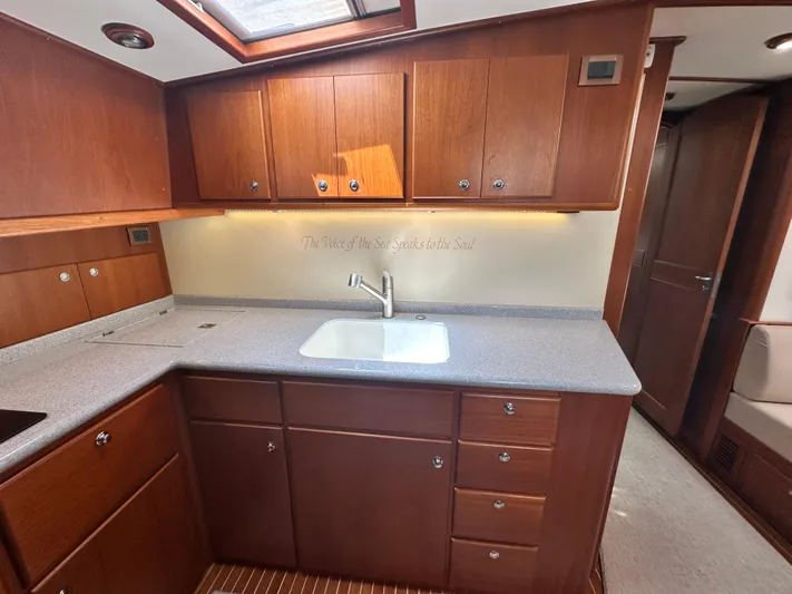 Bella Blue Yacht Photos Pics 2004 Grand Banks 49 Eastbay HX yacht kitchen with wooden cabinets and modern sink.