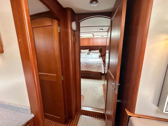 Bella Blue Yacht Photos Pics Interior of 2004 Grand Banks 49 Eastbay HX yacht, featuring wood paneling and a cozy bedroom.
