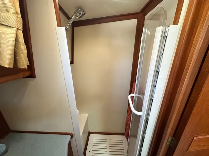 Bella Blue Yacht Photos Pics Shower area in 2004 Grand Banks 49 Eastbay HX yacht, featuring wood accents and modern fixtures.