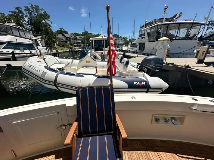 Bella Blue Yacht Photos Pics 2004 Grand Banks 49 Eastbay HX yacht with dinghy, docked in a marina under clear skies.